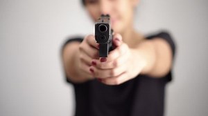 young woman asian girl holding a gun aiming at the gun, with selective focus