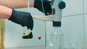 Laboratory Flask Handling by Scientist, Scientist pouring substance from flask to flask in a chemistry laboratory.