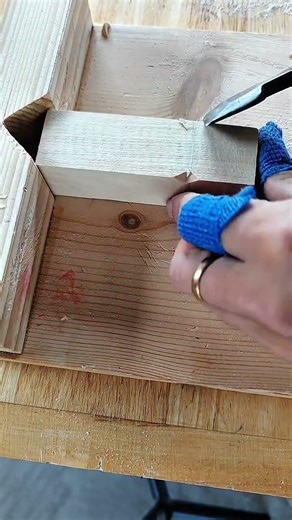 Marking cut line on wood inside miter box with chisel tool