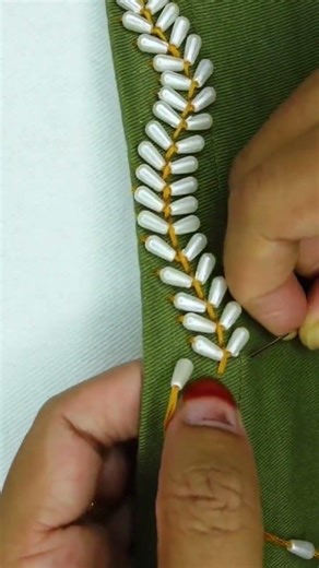 Beautiful white bead embroidery patterns crafted on olive green fabric
