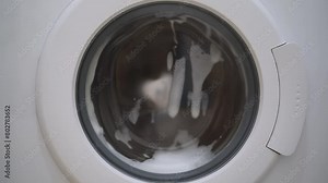 Washing machine washing clothes. Washing clothes with laundry detergent. Washing machine in the process of working Stock Video
