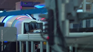Luggage exiting an X-ray TSA security scanner at an airport and empty bins returned