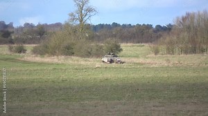 Army tracked fighting vehicle driving across countryside