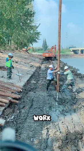Watch how simple tools do big work — workers guide each timber pile by hand #FieldEngineering #RiverDefense | Lara Amélia