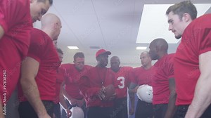 American football coach in locker room, psyching up players before the game