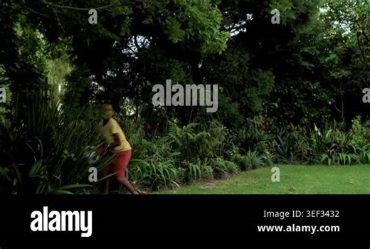 Reaching into shrubs, child is taking ball and practicing juggling in yard, stumbling, recovering. Soccer, kid, outdoor, lawn, greenery, overcast, neighborhood Stock Video Footage - Alamy