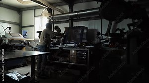 Craftsman Operates Machine For Wood Saw Sharpening By Rotating Hand Lever. Craftsman Rotating Sharpening Machine Handle At Workshop. Craftsman Controls Sharpening Machine By Rotating Stick Handle