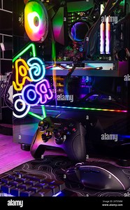 Vertical shot of colorful gaming pc desk with bright raimbow led computer gamepad mouse keyboard and steering wheel. esports video games concept  back Stock Photo - Alamy