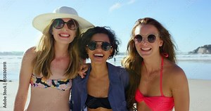 Travel, happy and friends in bikini at the beach for summer holiday, fun and relax while bonding at the sea. Diversity, women and girl group smile, bond and embrace, freedom and joy on trip in Miami