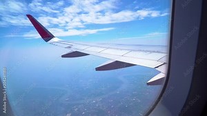 Traveling flight air transportation and Looking from airplane window, View through with red wing flying above the clouds.