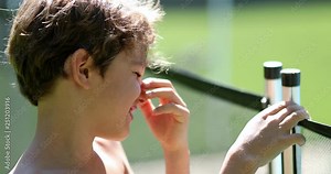 Irritated child trying to remove swimming pool safety fence Stock Video