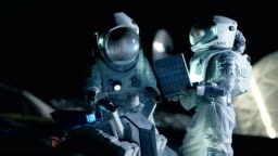 Two Astronauts in Space Suits on an Alien Planet Prepare Space Rover...