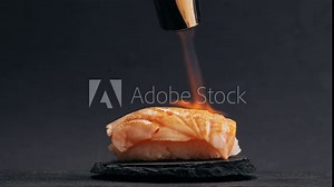 Chef cooking Sashimi Nigiri Platter with flambe fire, japanese sushi restaurant, Fresh Tuna and Salmon Slices in modern cafe, traditional food, raw red fish dish, omega 3.