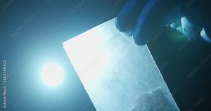 Police Evidence Examination. Police Detective Examining Meth or Cocaine at Crime Scene in Hand. Using Flash Light on Baggy of Drugs, Meth, Close