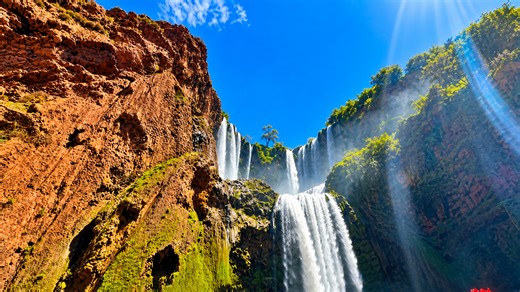 Waterfalls crashing through red canyon cliffs in Ouzoud