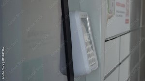 A hand puts a smartphone to the terminal. The concept of self-service order pickup by scanning a barcode through a self-service machine or parcel locker. Automated parcel terminal