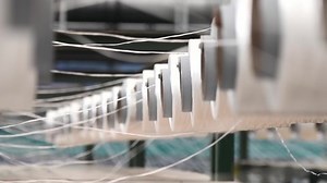 Textile industry - yarn spools on spinning machine in a textile factory