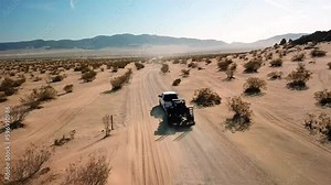 Truck towing trailing on a desert dirt trail