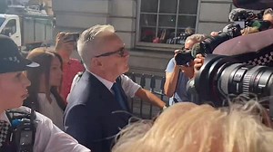 Huw Edwards wears navy-blue suit and black sunglasses outside court