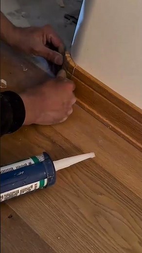 Installing wood baseboard corner trim with precision using adhesive sealant