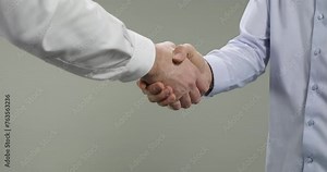 Long handshake, agreement and partnership between business people. Closeup of two men handshaking after a successful deal, isolated on grey background