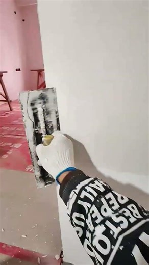 applying putty and smoothing the walls using a trowel to create a flat and even surface