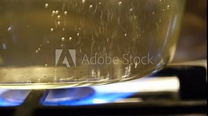 The process of boiling water slow motion. Water is boiling in a pan close-up. Boiling water in a transparent pan.