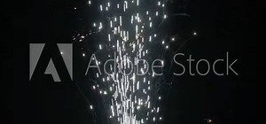 Slow motion shot of fireworks producing an upward shower of sparks against a black background. Commonly known as a gerb, this pyrotechnic is also called a sparkling fountain or waterfall.