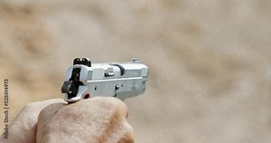 Pistol shooting bullets in slow motion footage. Hand guns in firing range
