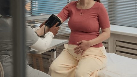 clip-4005739195-black-female-doctor-measuring-caucasian-pregnant-woman