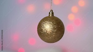 A golden New Year's ball rotates against a background of blurred multicolored garlands. The defocused light bulbs blink and change color. Blurred New Year's background Stock Video