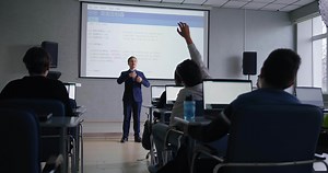 School Students Discussing Computer Science Project Of Classmate In Programming Lesson in School