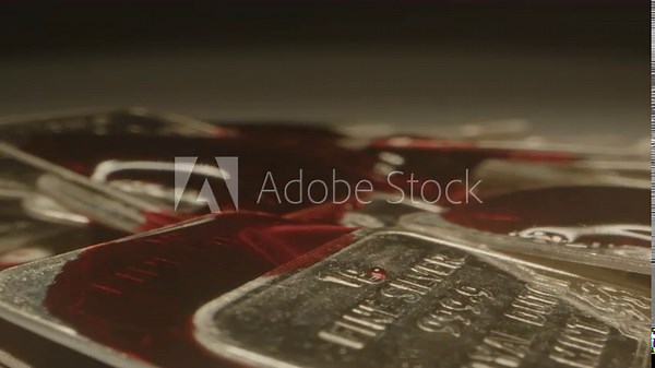 Extreme close up of blood dripping on silver bars. The blood slowly flows over the shiny precious metal plates Stock Video