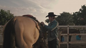 Rancher man tying a saddle chair to a horse - Free Stock Video