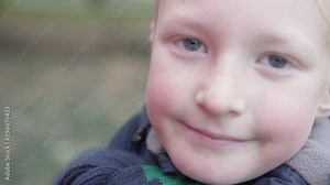 The boy quickly spins in a circle on a swing. Close-up of a blond child spinning on a swing in autumn in a park