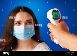 Brunette Woman Getting Temperature Screening With Infrared Thermometer