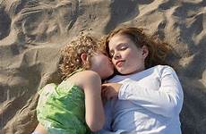 kissing sisters beach two cheek lying