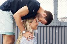 leaning over man woman her kissing smiles alamy while she