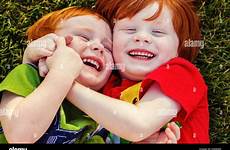 boys happy two laughing lying grass alamy