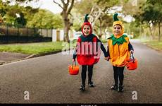 halloween costume trick treating sisters twin walking identical bucket sidewalk kids two alamy outdoors little girls