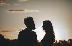 couple silhouettes sunset standing field during young
