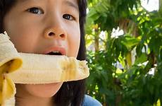banana child asian eating girl bite eat joy chew concept stock similar