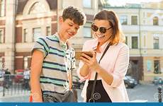 adolescente genitore adolescenti figlio tiener stanno verhouding ouder zoon moeder ridendo cellulare esaminando relazione telefoon mobiele stadsstraat bekijken lachen houdend