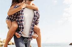 girlfriend ride beach back piggy giving man his stock piggyback
