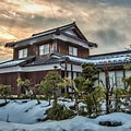 Rumah tradisional Jepang dengan latar belakang gunung yang mempesona