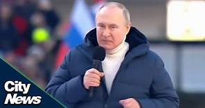Putin appears at a huge flag-waving rally inside a Moscow stadium