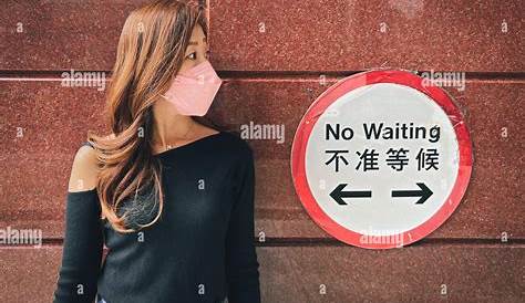Woman standing against wall next to no wiring sign Stock Photo - Alamy