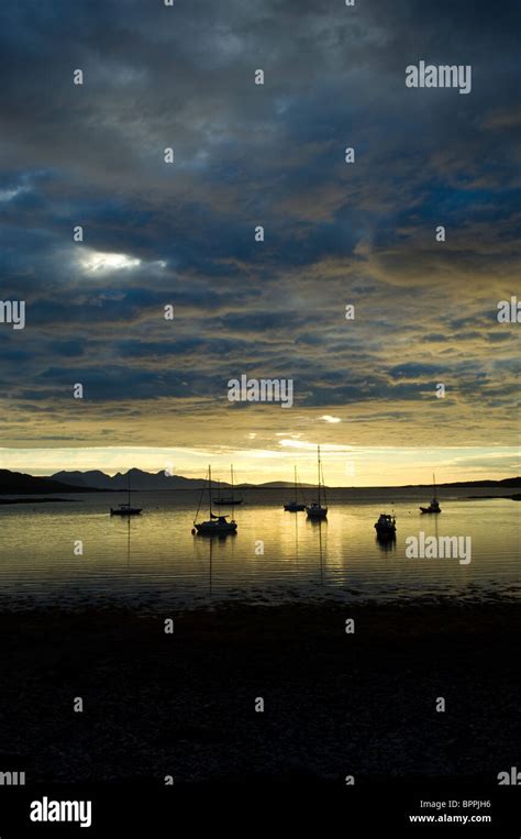 Sunset Over The Isle Of Rum With Moored Sailing Boats From The Shore Of