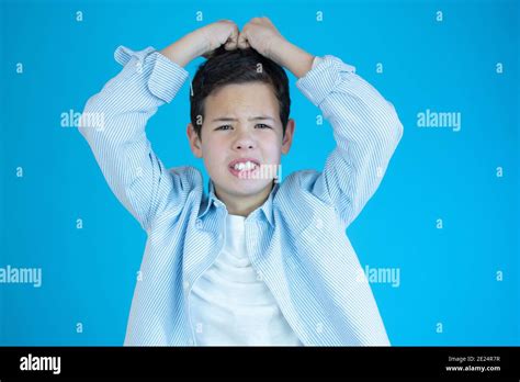 Young Boy Scratching His Head Isolated Over Blue Background Stock Photo