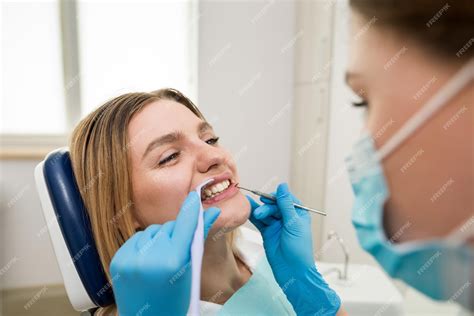 O Dentista Verifica Os Dentes De Um Jovem Paciente Sentado Em Uma